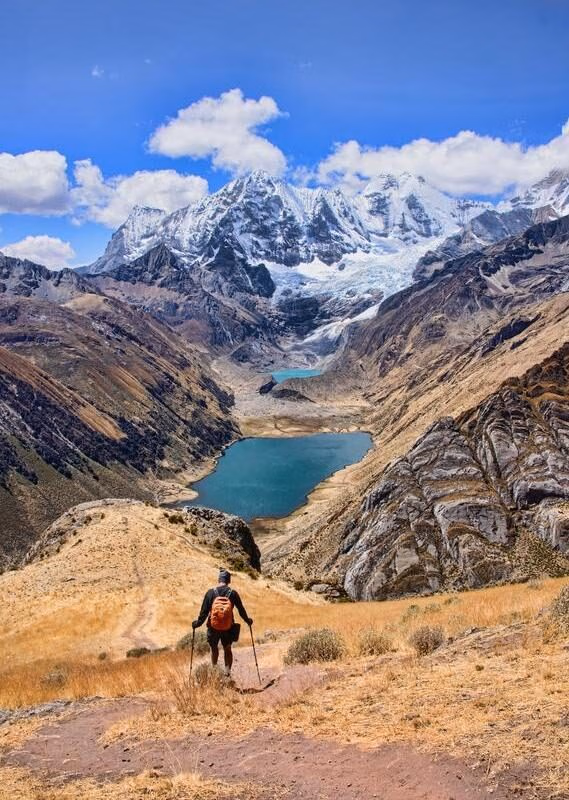 Luxury Peru Tours - A trekker descending down to Laguna Jahuacocha and the entire Cordillera Huayhuash, Ancash, Peru.