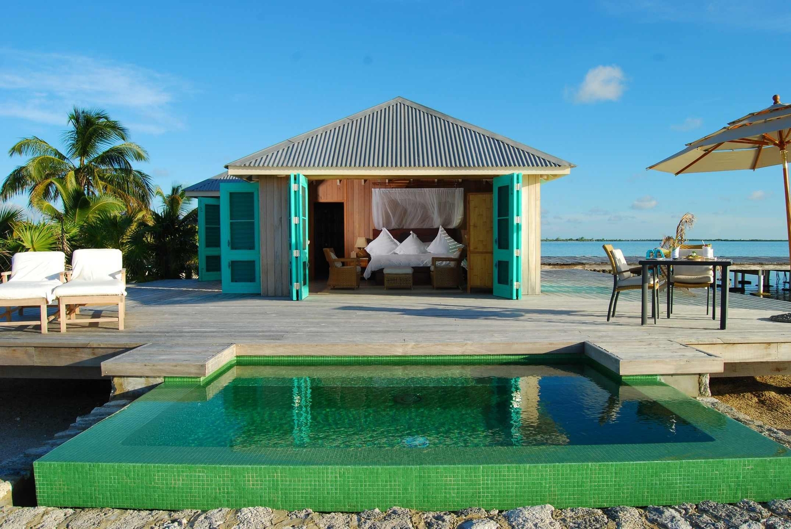 One of Cayo Espanto's beachfront villas with a plunge pool that's open to give you a view into the bedroom.