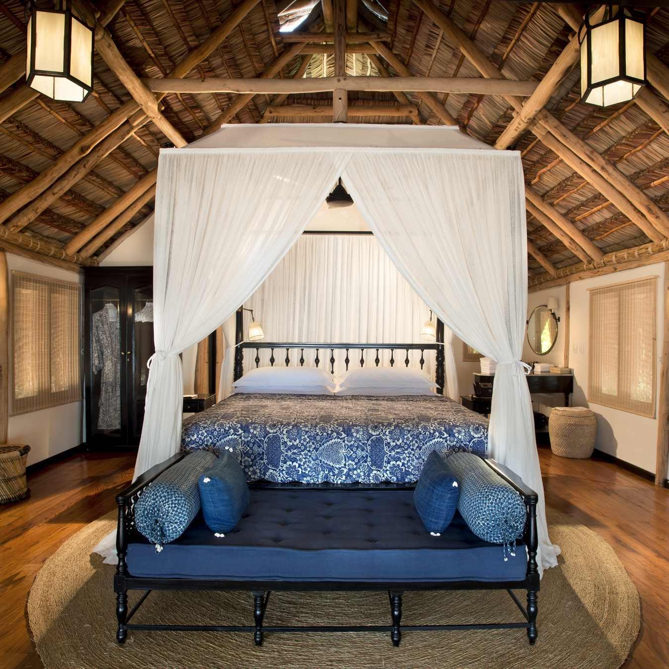 A bedroom of a casita or villa at andBeyond Benguerra Island, featuring a canopy bed.
