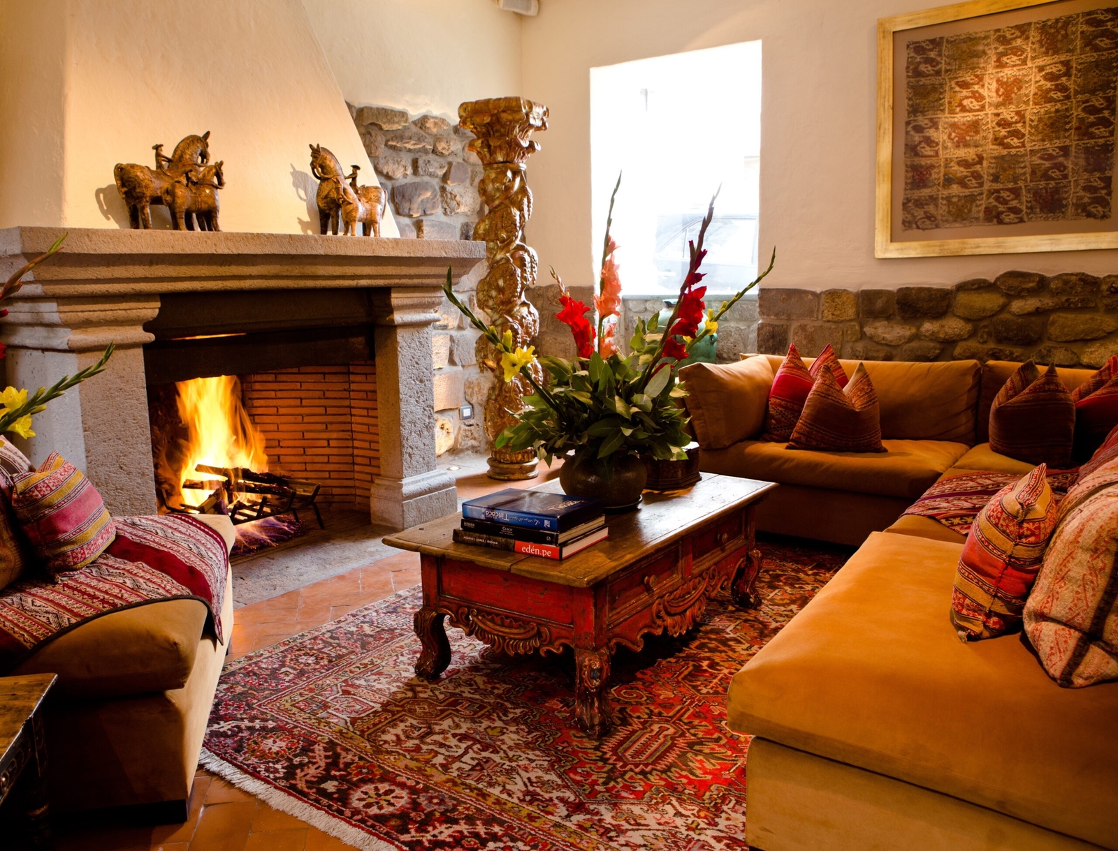 Cozy living room with a lit fireplace, ornate rugs, and comfortable seating.