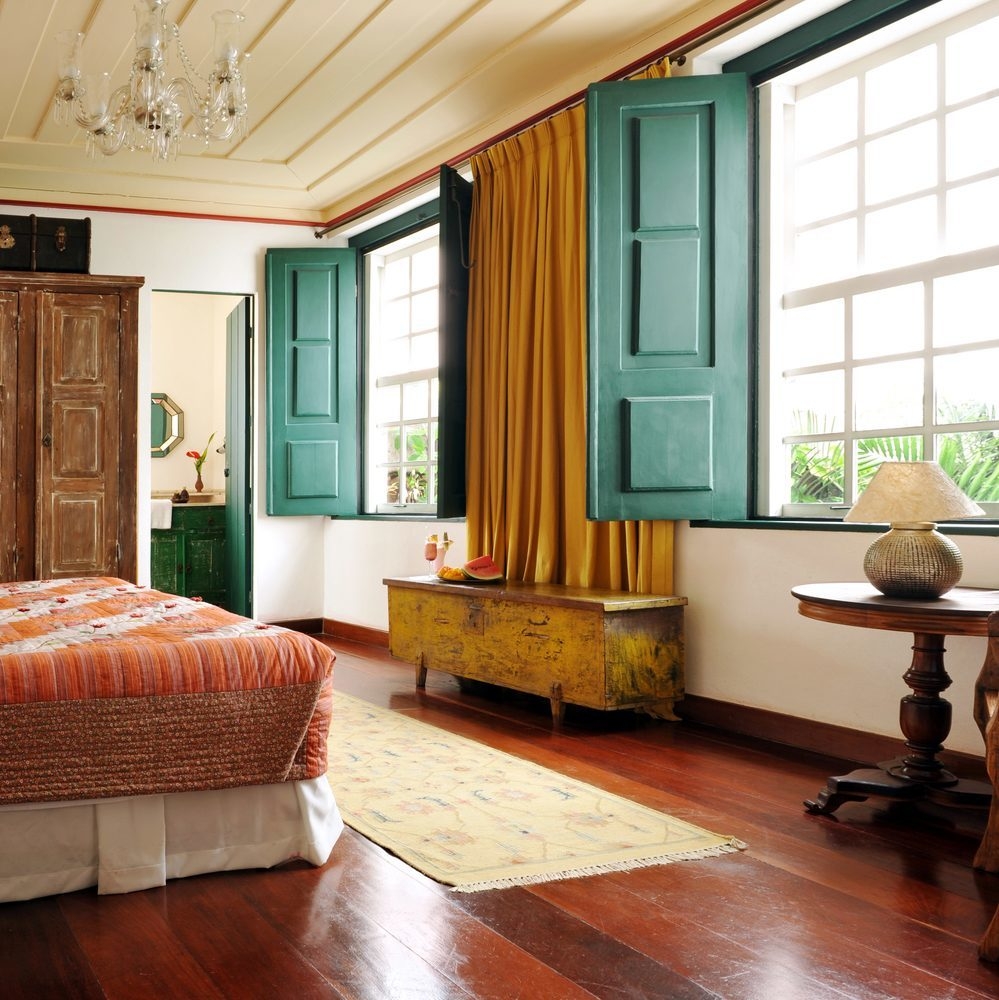 A colourful guest room with blue shutters at Villa Bahia, Salvador