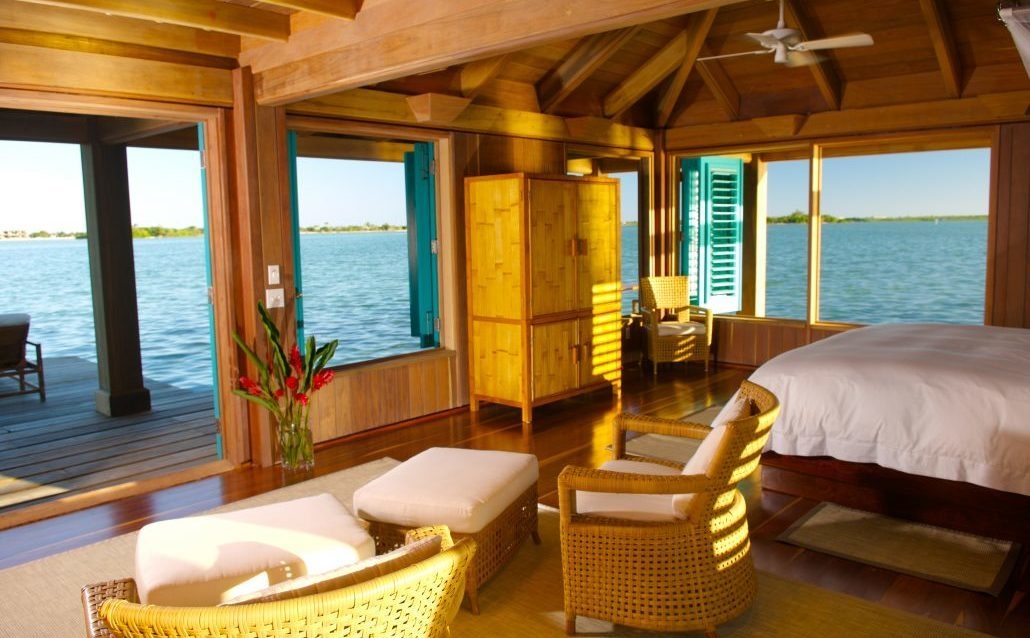 The bedroom of Cayo Espanto's overwater villa overlooking the Caribbean.
