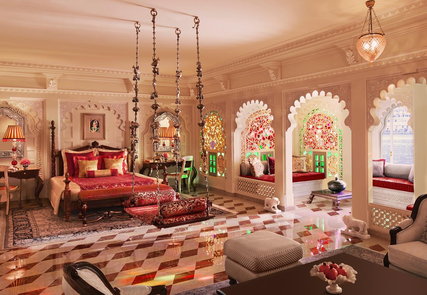 A stately, ornately-styled bedroom at Taj Lake Palace which faces the lake.