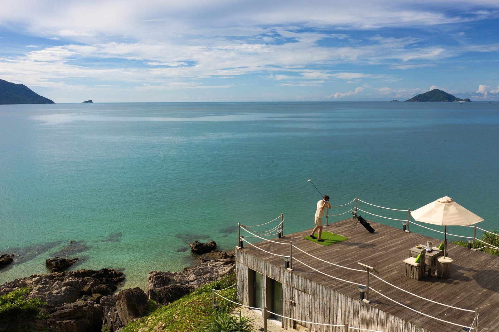A man playing feed the fish golf at Six Senses Con Dao