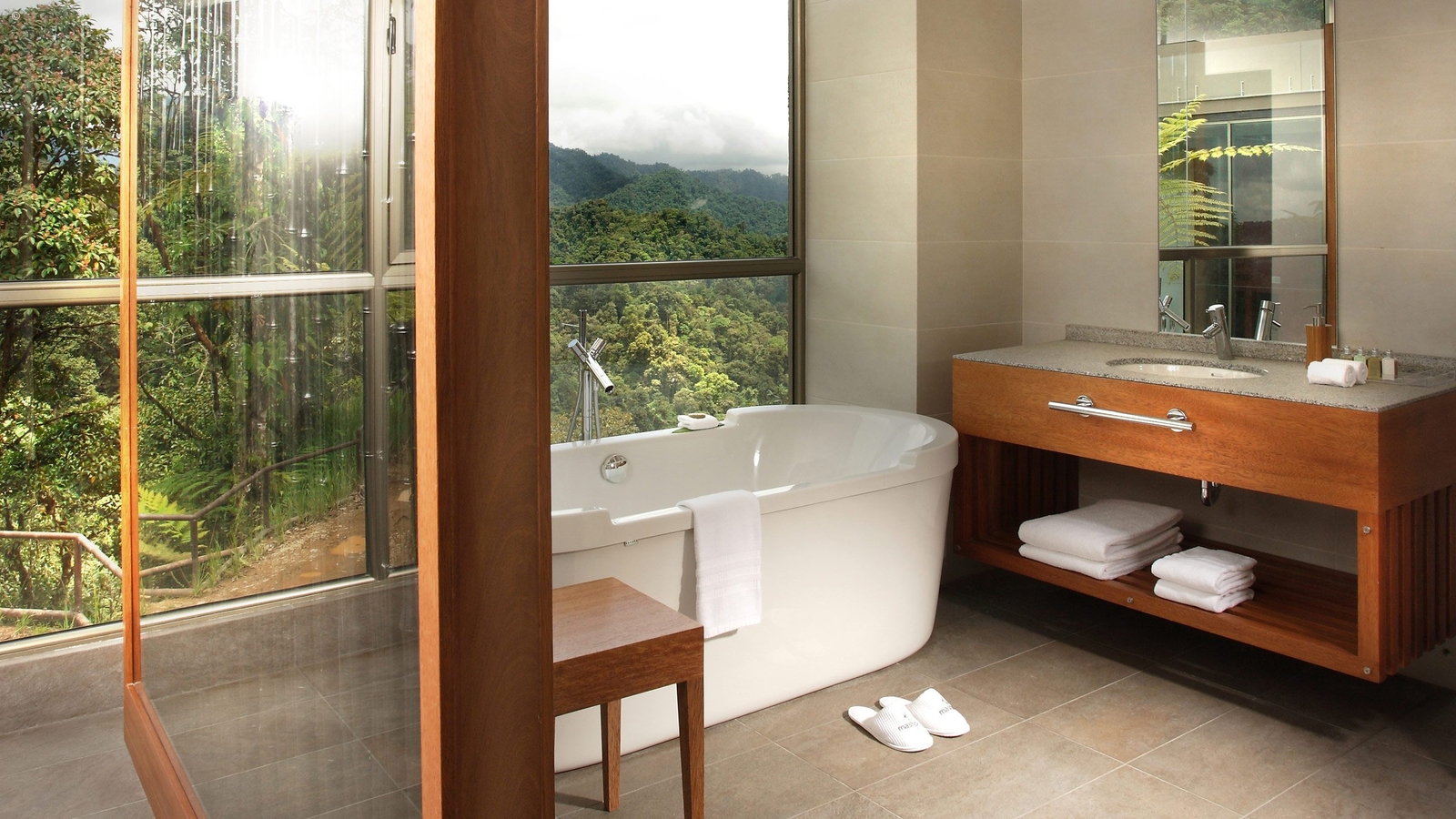 A freestanding tub in a bathroom at Mashpi Lodge with views out to the surrounding forest.