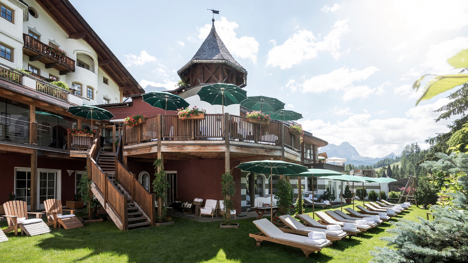 Exterior of Rosa Alpina, row of sun loungers on a summer's day, San Cassiano Italy