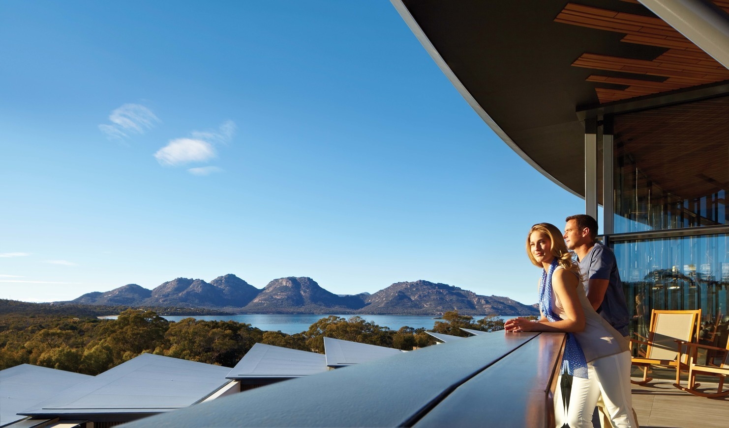 A couple admiring the views from the outdoor terrace at Saffire Freycinet