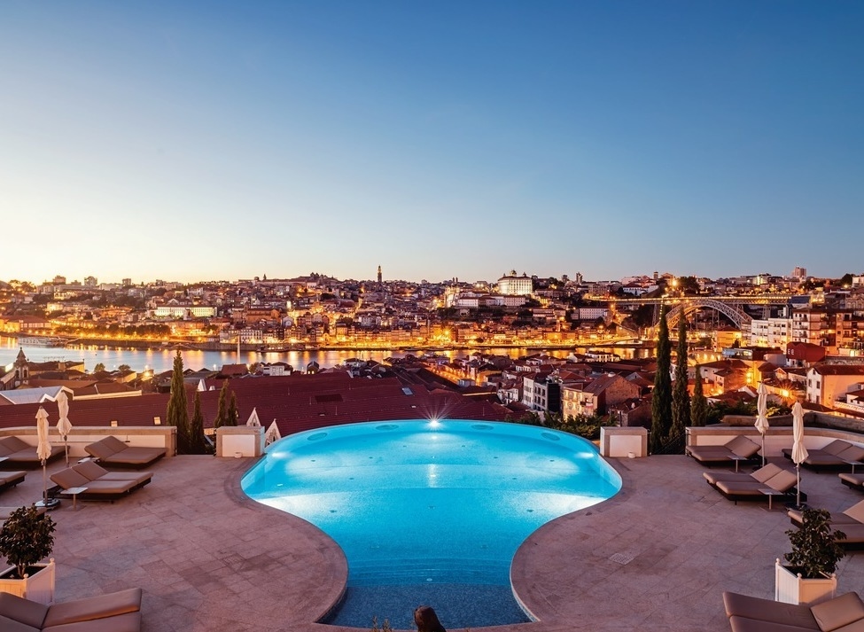 Infinity pool with terrace overlooking the city of Porto at dusk at The Yeatman hotel