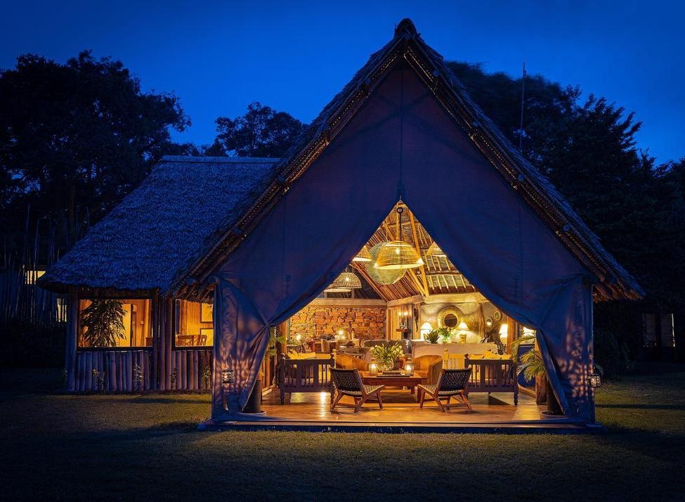 A lounge tent lit up at night at House in the Wild