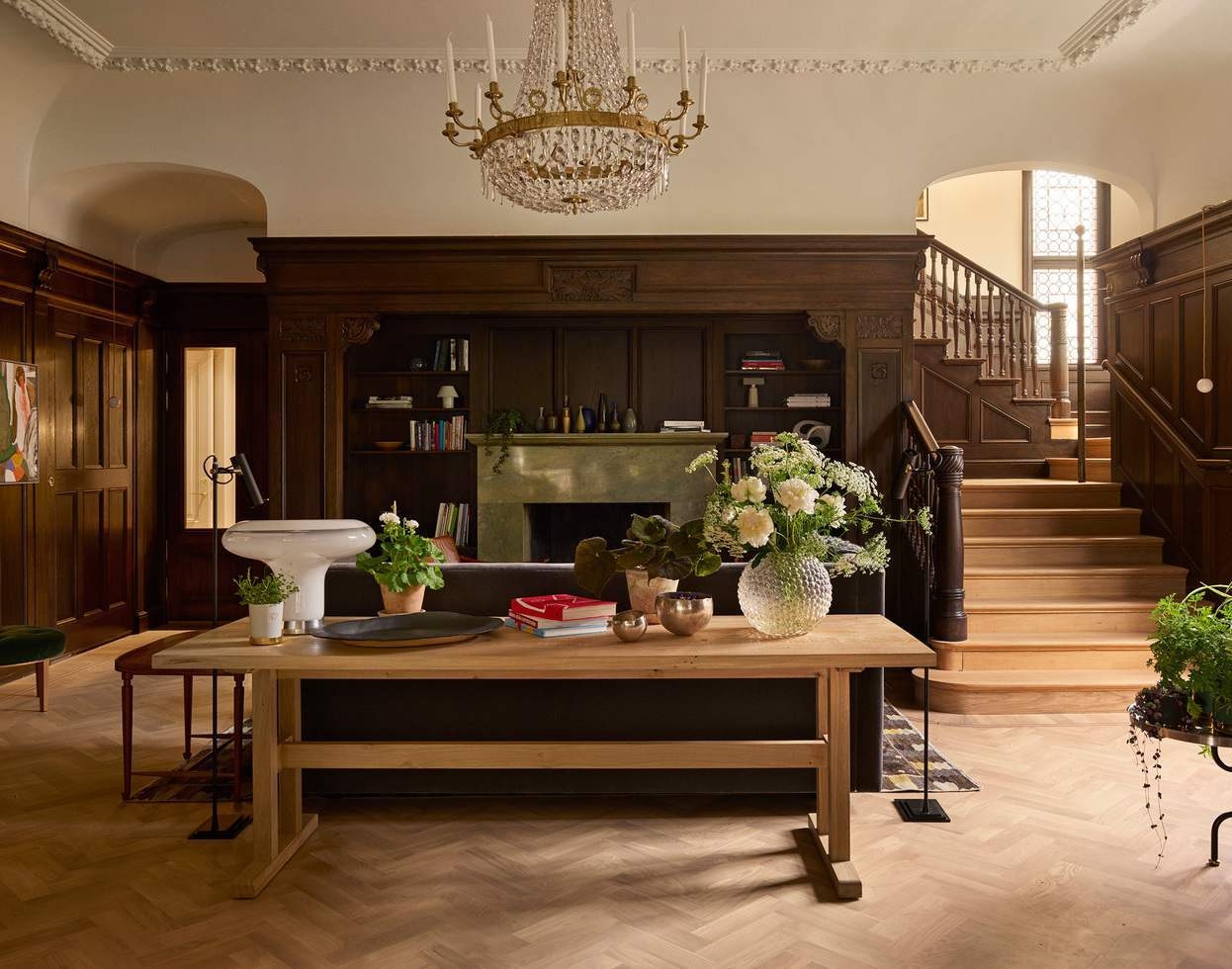 The lounge area at Ett Hem decorated with elegant woods and an intricate chandelier.