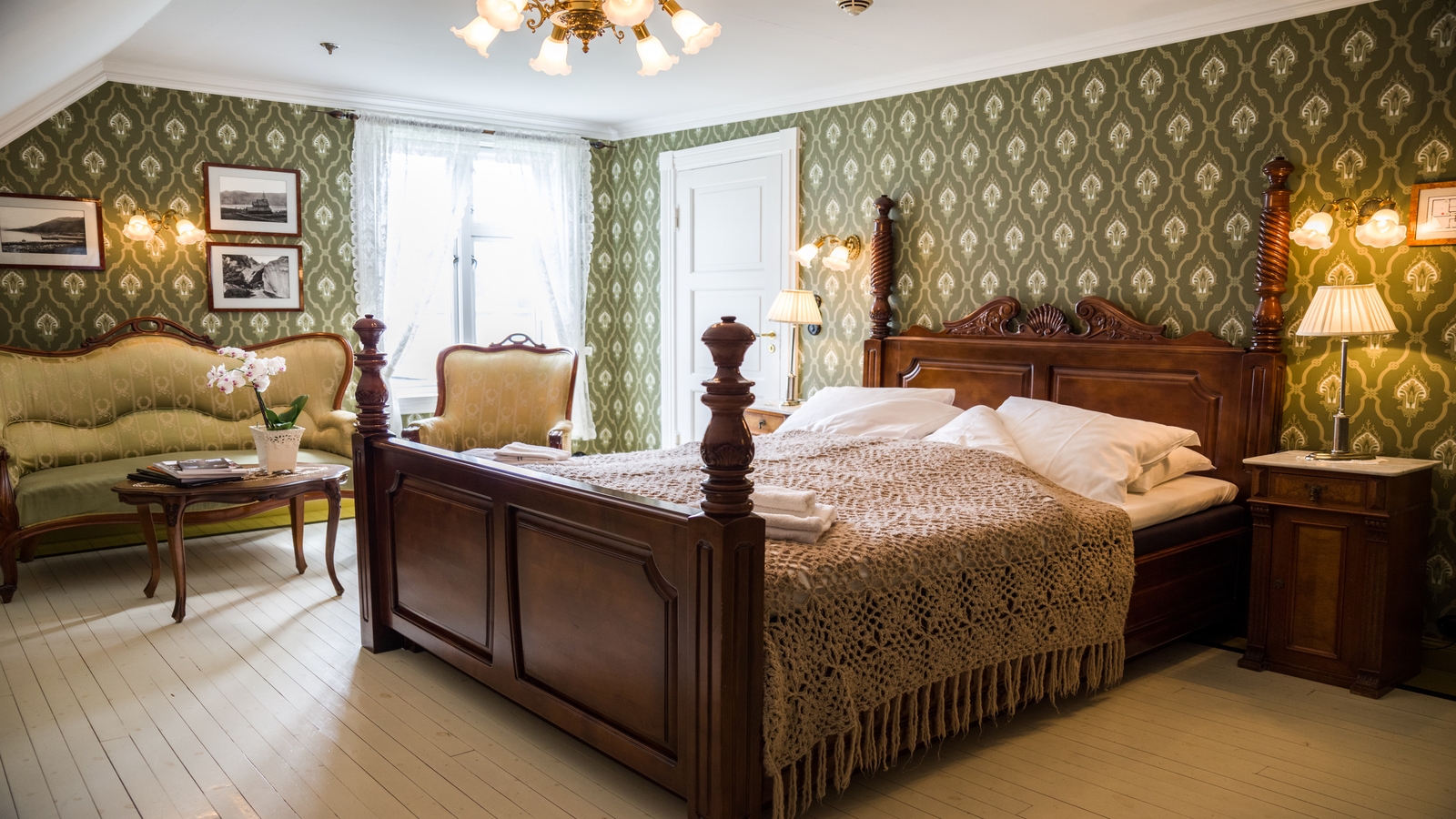 Elegant vintage bedroom with patterned wallpaper, wooden furniture, and white linens.