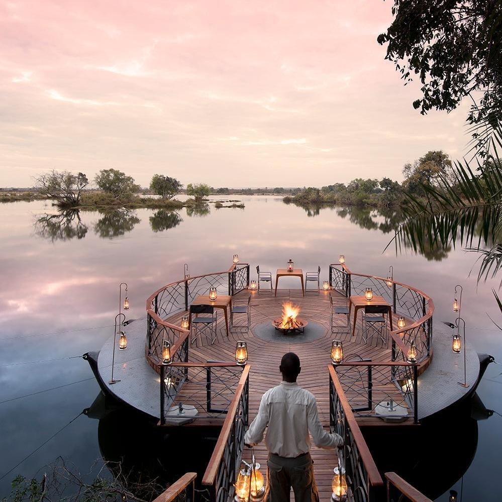 Outdoor deck at Thorntree River Lodge featuring dining tables and sweeping views of the Zambezi River.