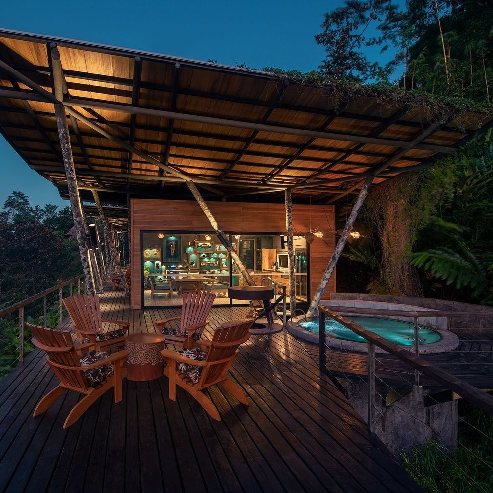 Outdoor terrace with dining table and pool at Origins Lodge, Costa Rica