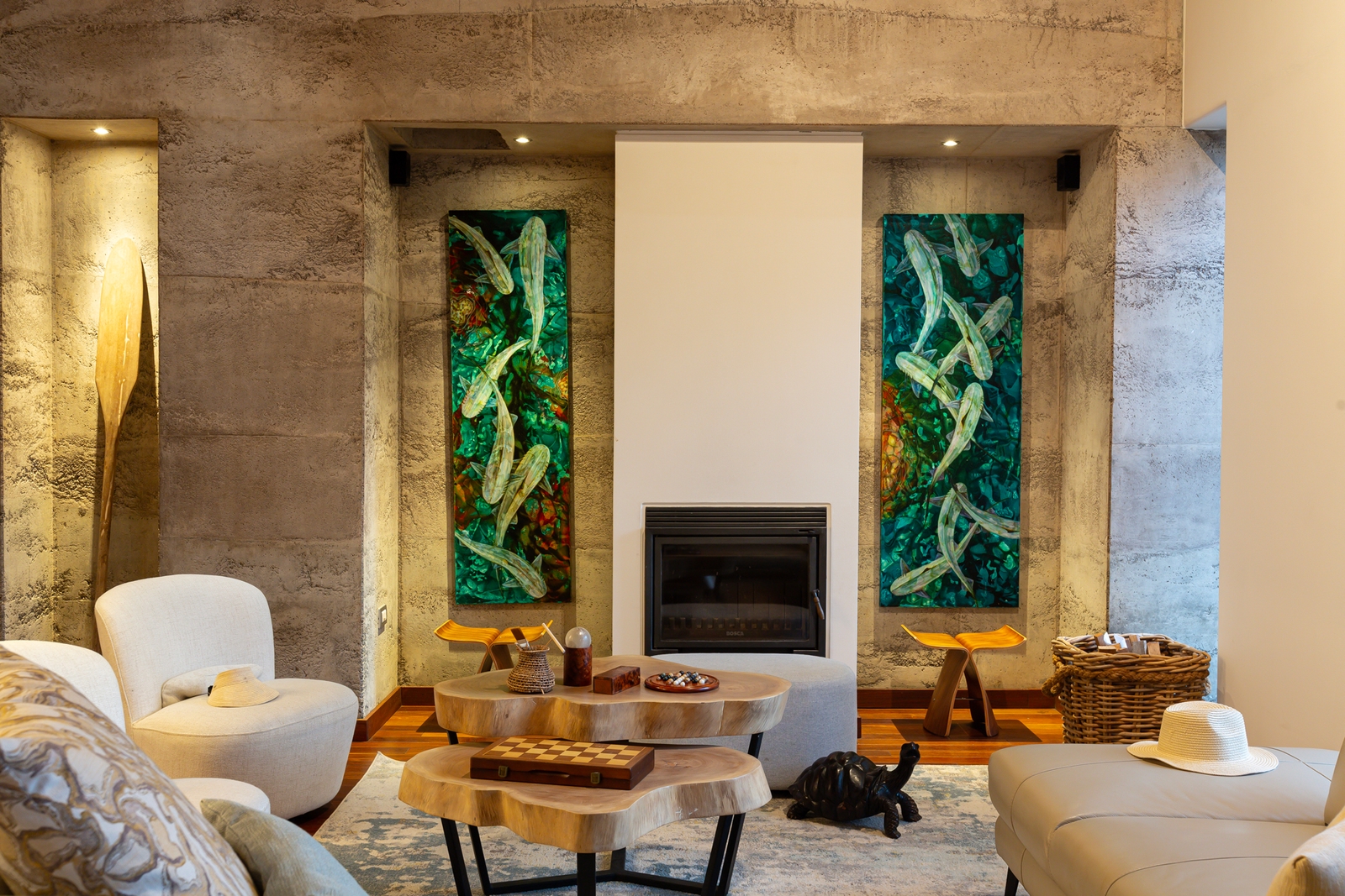 Modern living room with fireplace, abstract art, cozy furniture, and wooden accents.