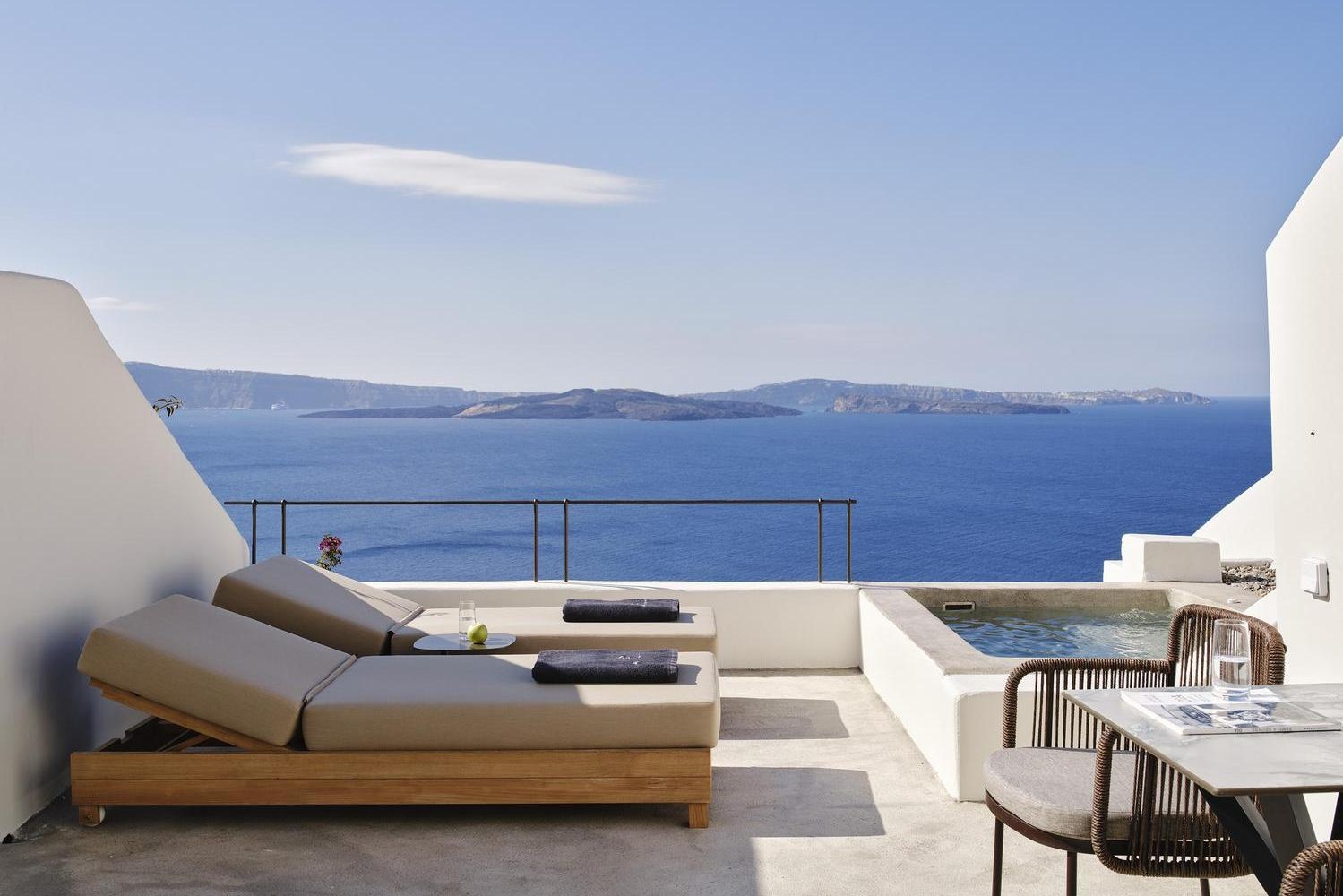 Terrace with sunloungers and ocean views at Andronis Luxury Suites