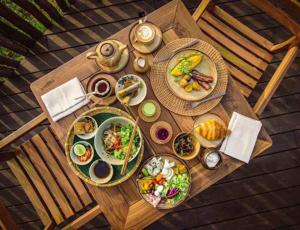 A top-down view of a gourmet breakfast spread on a wooden table at Namia River Retreat.