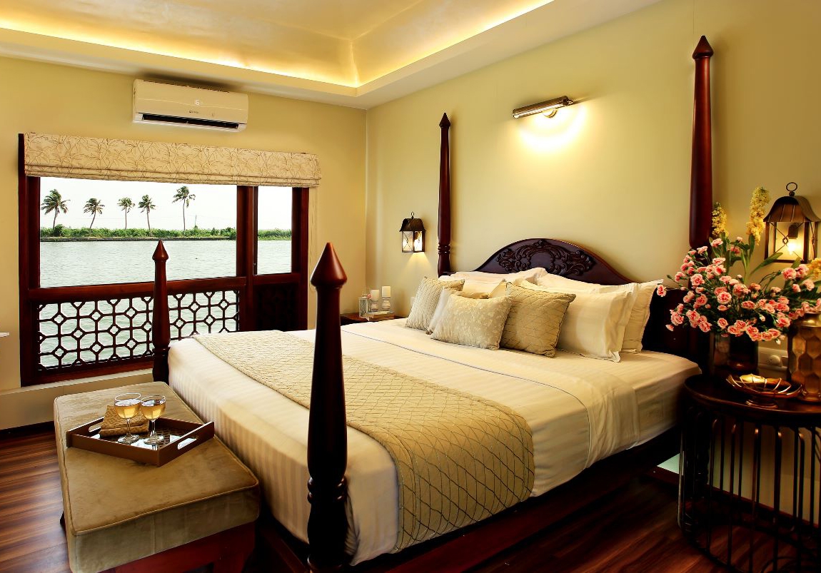 Elegant bedroom with a large bed, warm lighting, and river view from the window.