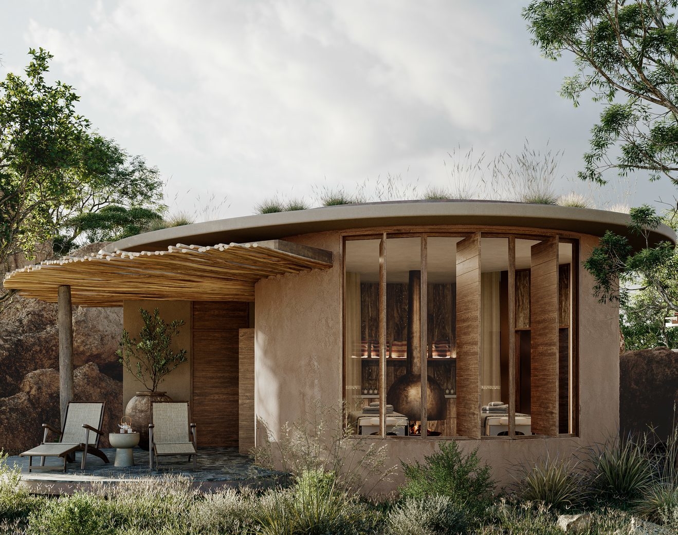 Earthy-toned round cabin with grass roof, wooden slats, and outdoor loungers in a natural setting.