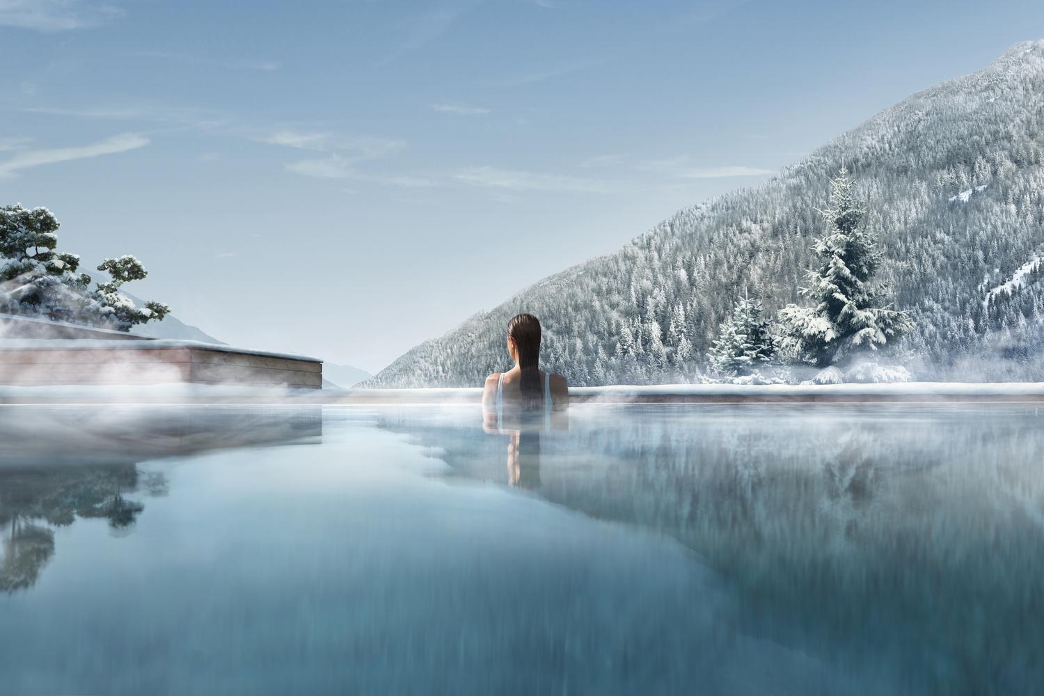 A woman in the outdoor pool in winter at Lefay Dolomiti