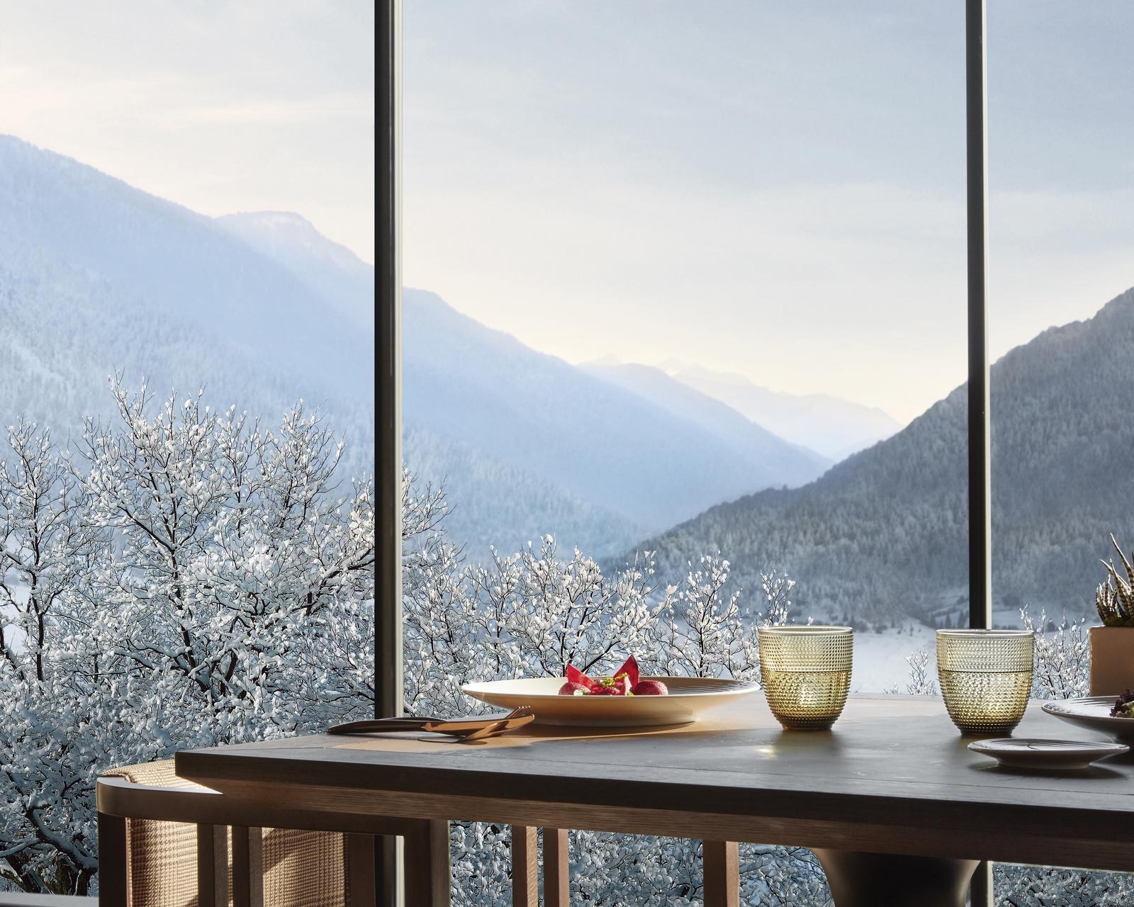 A table at Dolomia restaurant with views onto winter landscapes at Lefay Dolomiti