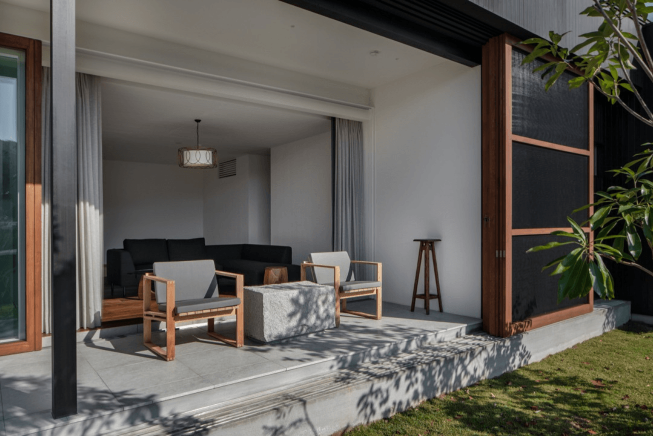 Covered terrace at ground level with two chairs and a square table