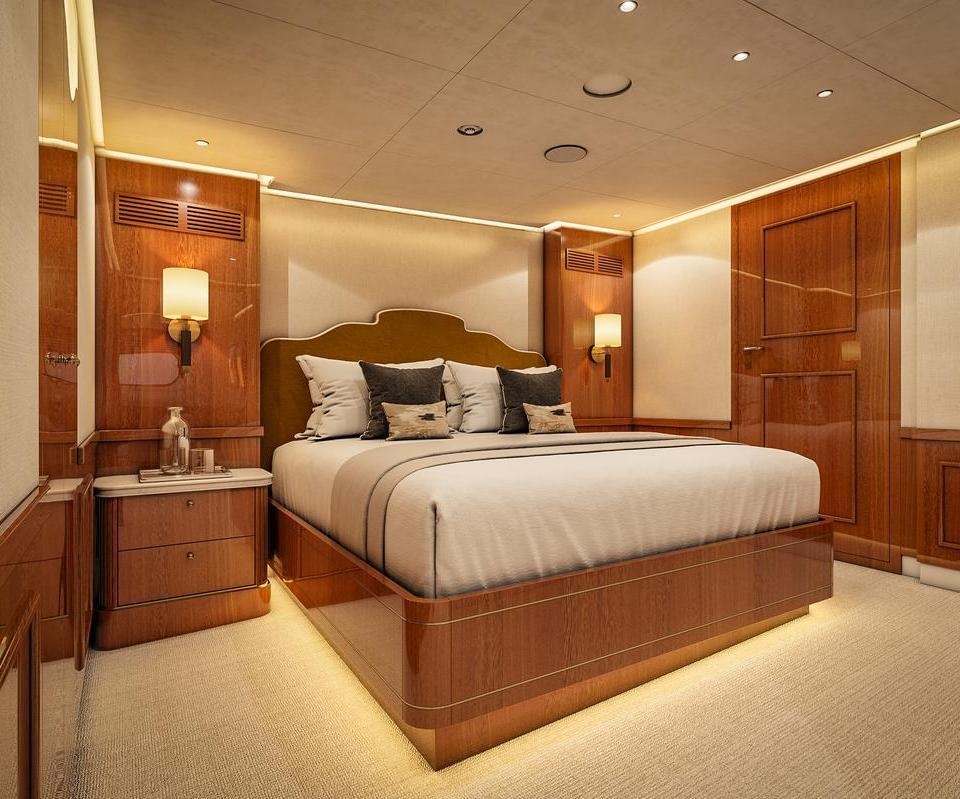 The bedroom of the Owner's Suite onboard luxury expedition cruise Aqua Lares which is decorated in warm woods.