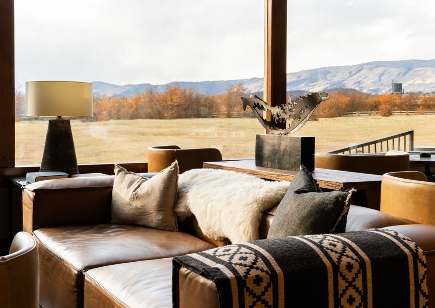 Close-up of large sofa in the lounge with a window behind showing open countryside.