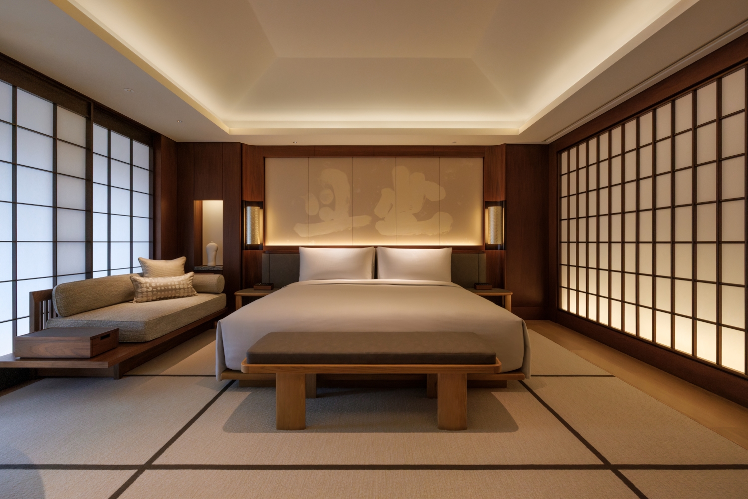 Interior bedroom with neutral-toned bedding and soft lighting with traditional Japanese screen walls.