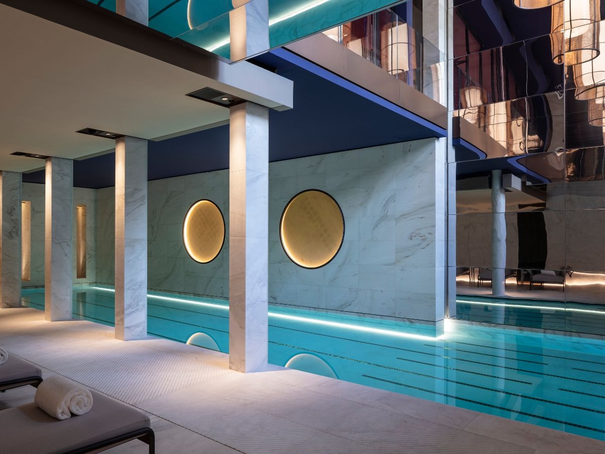 An indoor swimming pool with marble walls and columns