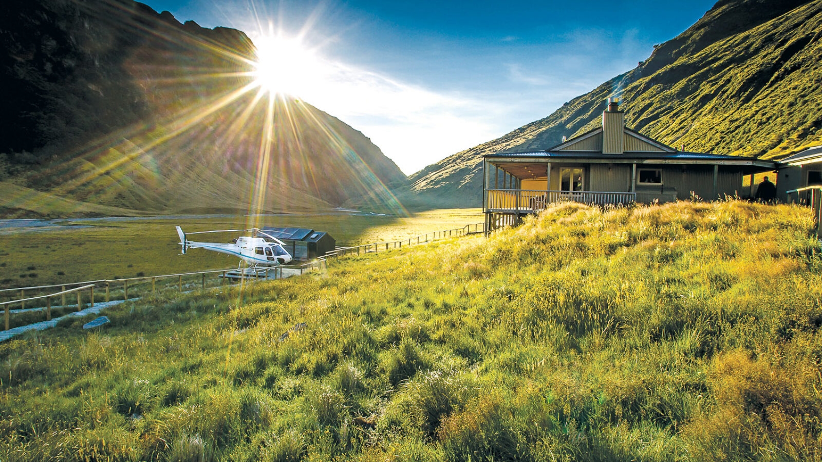 Sun rising over a mountain and grassy plain