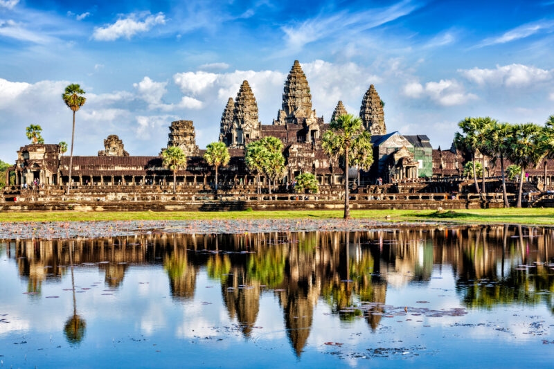 The majestic spires of Angkor Wat reflect perfectly in the still water of the surrounding lily pond during Asia honeymoons.