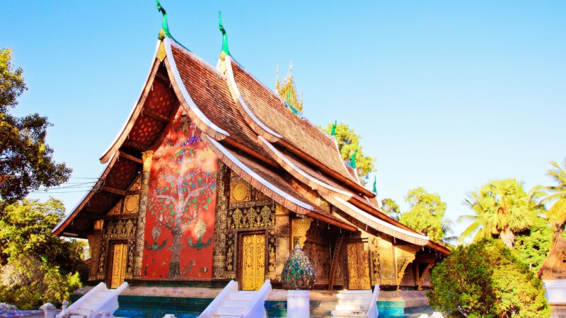 Intricate glass mosaic of the Tree of Life on a temple wall, a detail of luxury Laos holidays.