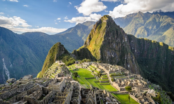 Panoramic view of the ancient Incan citadel of Machu Picchu and surrounding green mountains.