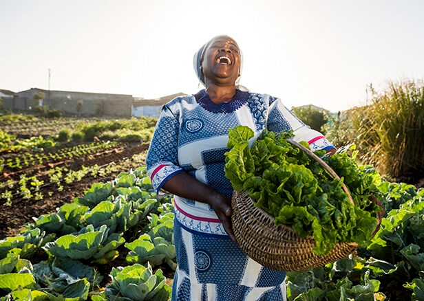 Luxury South African Safaris and Tours - woman farming and laughing while holding crops
