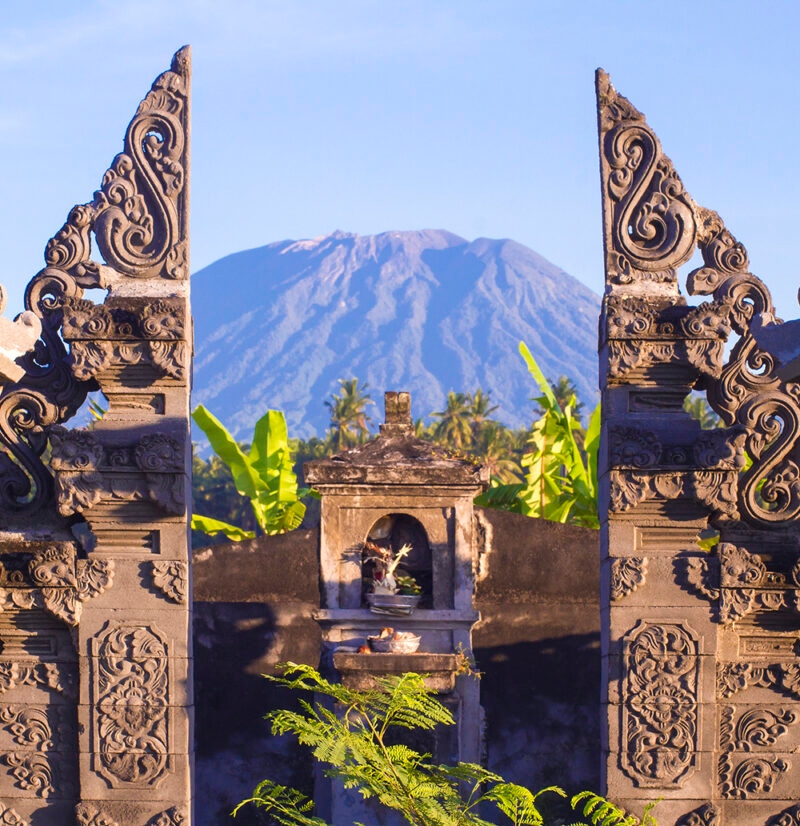 A large volcano framed by stone temple gates, a scenic view on luxury Bali trips.