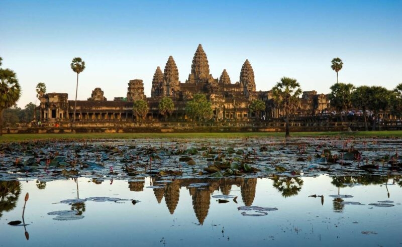 Angkor Wat, an ancient stone temple reflected in a pond during luxury Southeast Asia vacations.