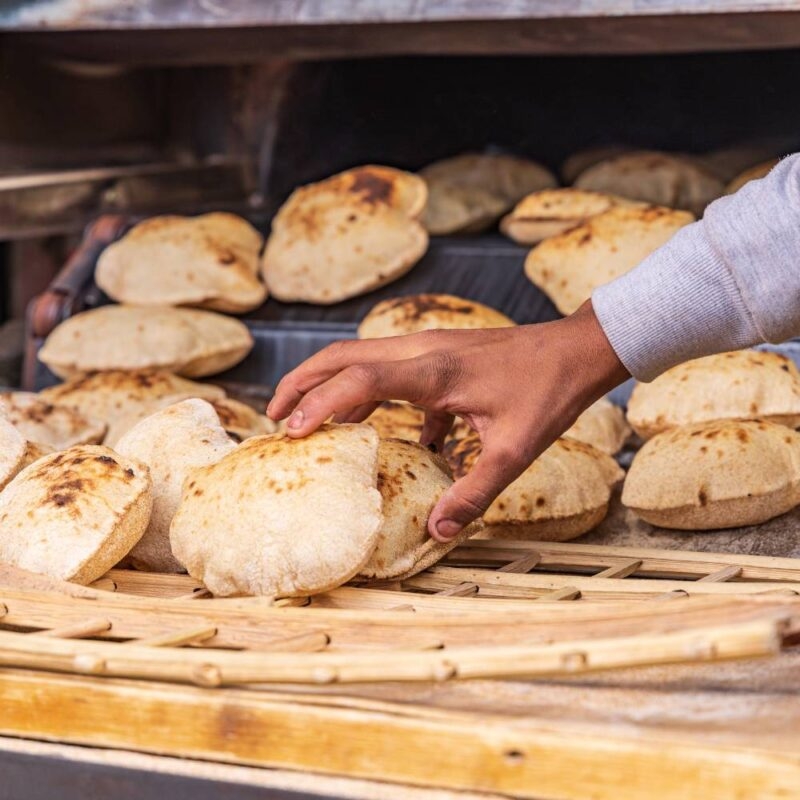 Luxury Egypt Tours - a hand reaching to pick up a puffed up pita bread