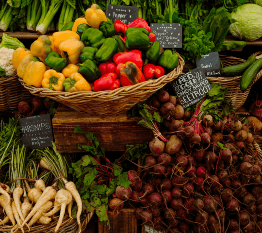 Fresh organic vegetables including red peppers and beetroots for luxury Cape Town vacations at a local market.