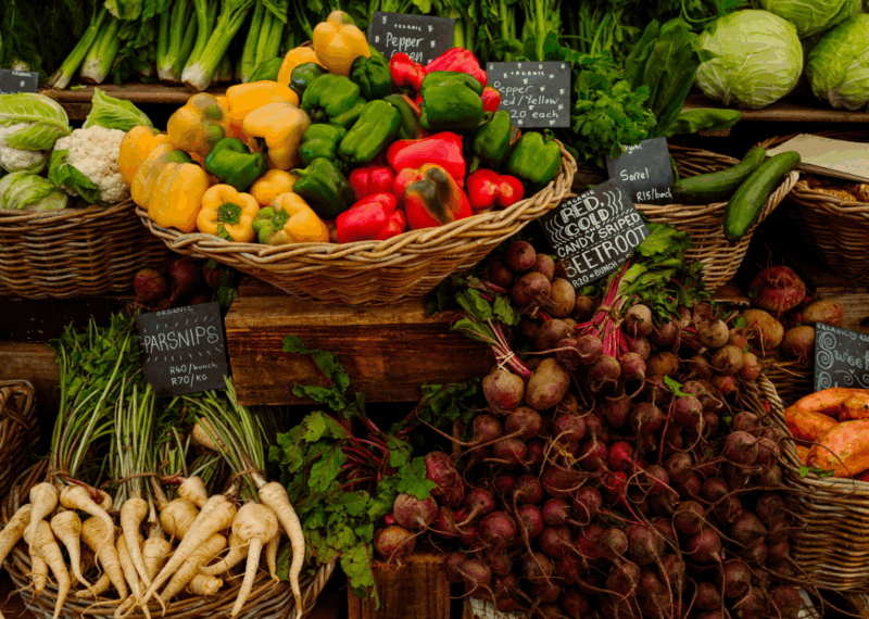 Fresh organic vegetables including red peppers and beetroots for luxury Cape Town vacations at a local market.