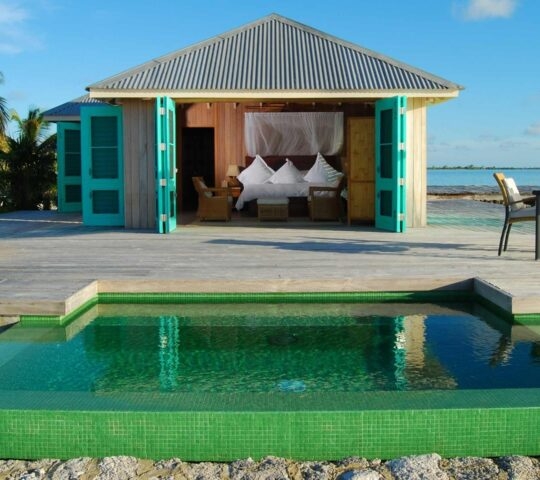 One of Cayo Espanto's beachfront villas with a plunge pool that's open to give you a view into the bedroom.