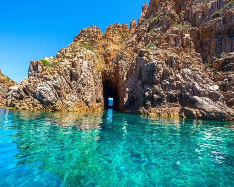 Rocky cliffs surrounded by turquoise water at the Calanques de Piana in Corsica