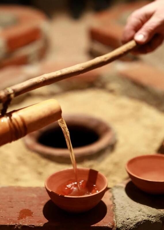 Person pouring wine from qvevri using Orshimo, Georgia