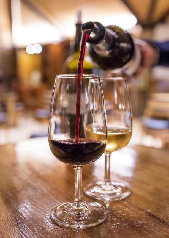 Close-up of red wine being poured into a crystal glass at a vineyard during luxury Tuscany holidays.
