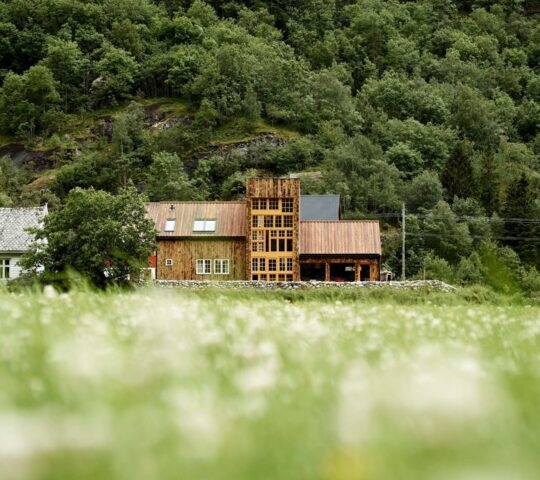 The exterior of 29/2 Aurland seen from a distance over green fields