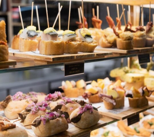 Small pieces of tapas lined up on a counter at a bar in Spain