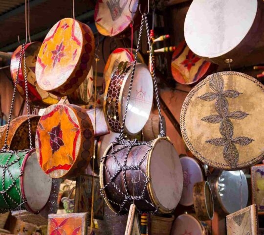 Decorative Moroccan drums hanging up on display at a market stall