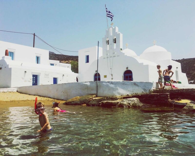 children in snorkel masks playing in the sea in Greece
