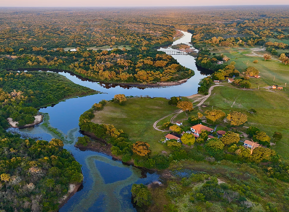 An aerial view of a lodge set beside a river in The Pantanal.