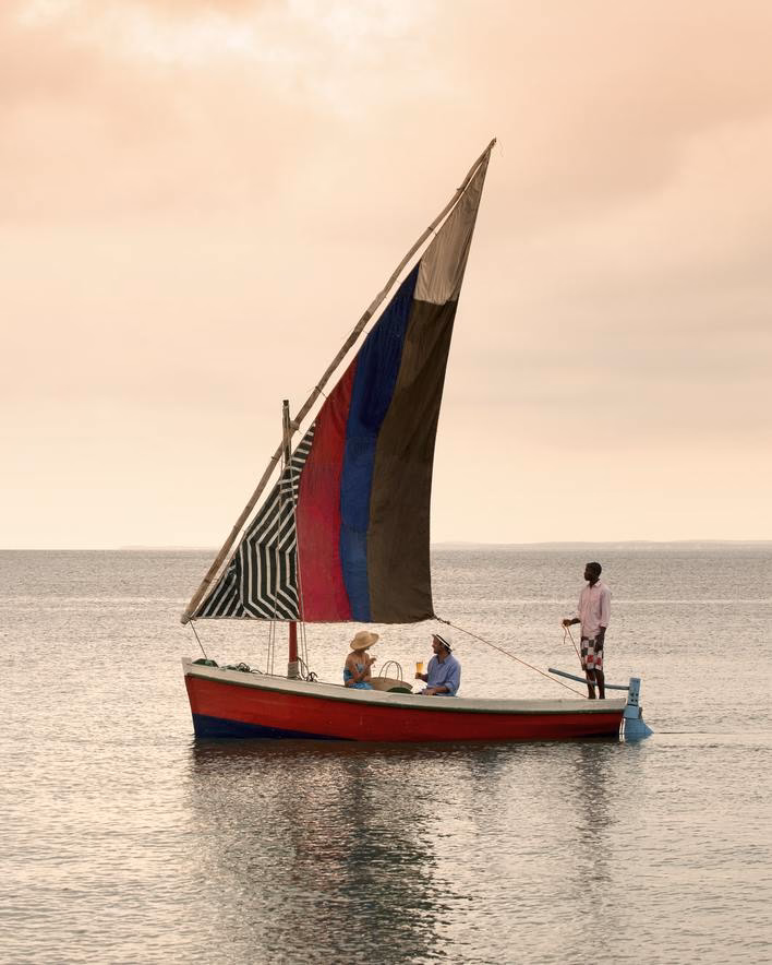 A couple cruising on a traditional dhow at sunset.