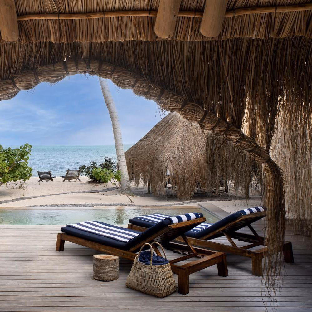 A glimpse of a pool area at andBeyond Benguerra Island, featuring a pair of sun loungers.